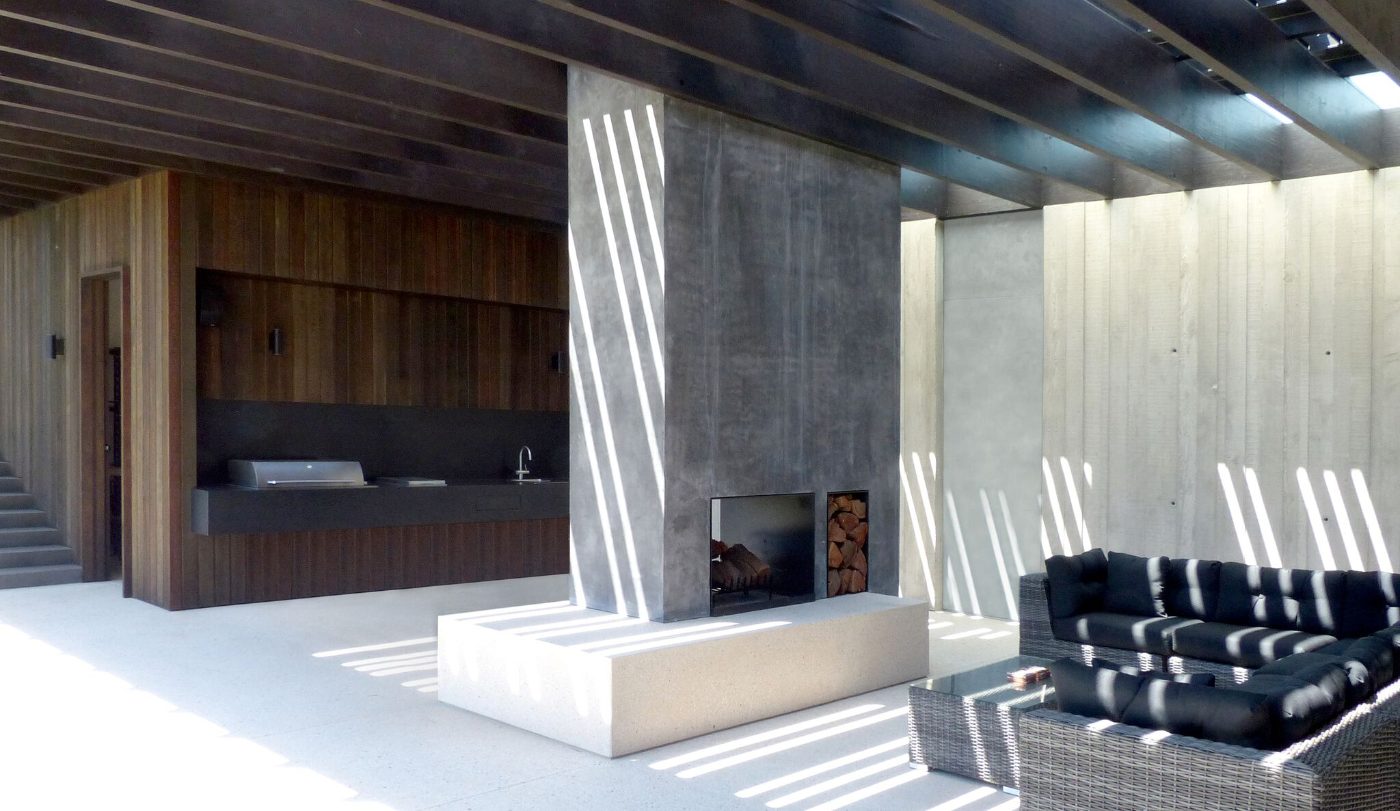 Outdoor room with concrete hearth and timber batten ceiling, inner-east new build