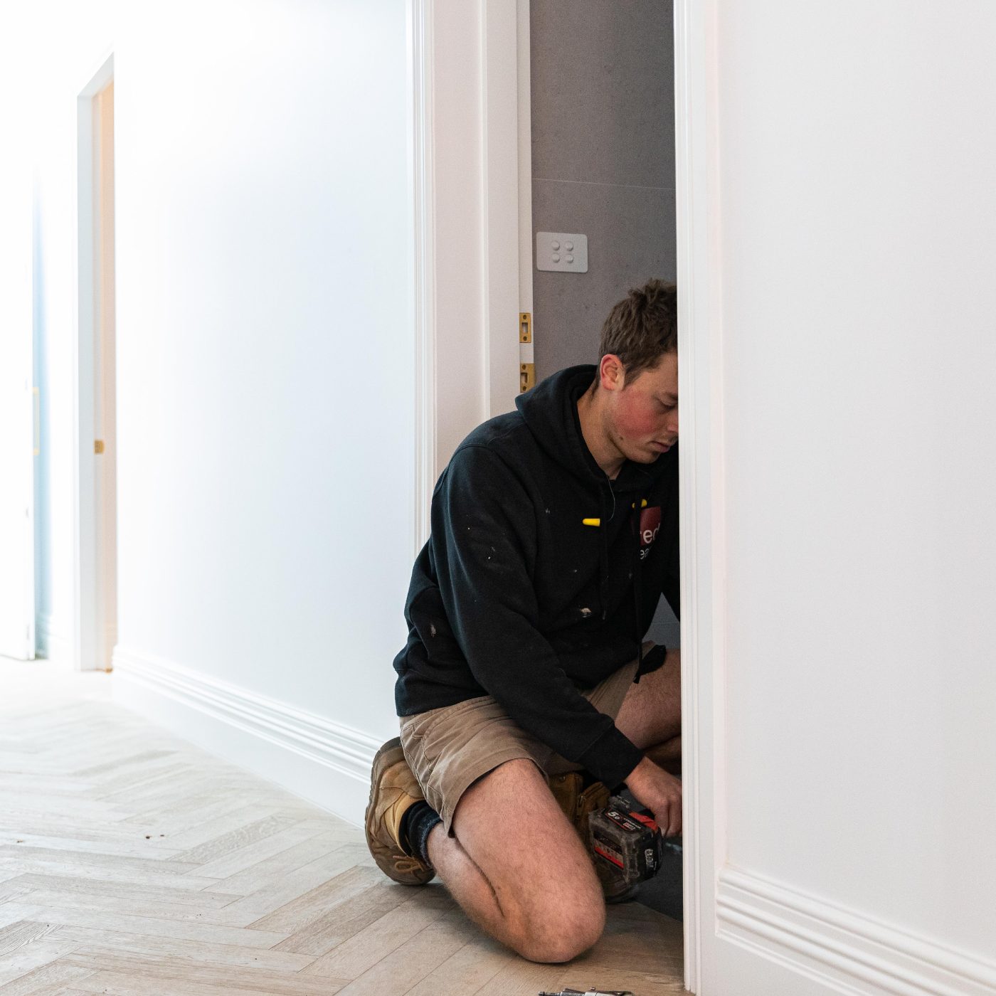 Carpenter hanging an internal door during finishing works in Richmond